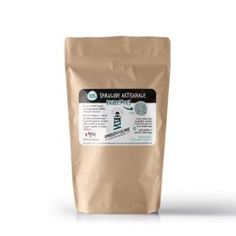 Spirulina flakes, a nutritional supplement made from a type of blue-green algae. The product is packaged in a resealable paper bag, with a label that includes information about the product's artisanal production and health benefits.