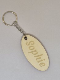 Personalized name keychain, oval shape, engraved text, girls names, metal ring, gift accessory.