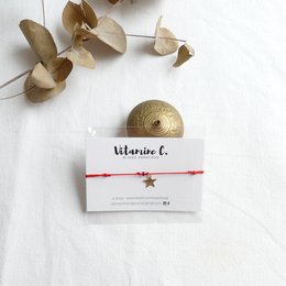Red charm bracelet with gold-colored charm