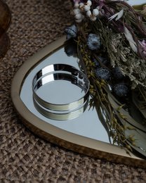 Silver and orange cuff bracelet with a mirrored surface and floral accents.
