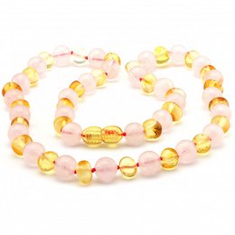 Baroque-style necklace featuring a mix of baltic amber and rose quartz beads in warm tones. The necklace has a classic, elegant design suitable for everyday wear.