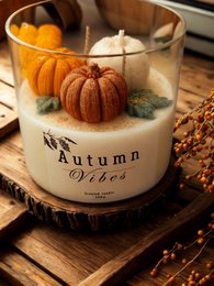  Autumn-scented candle with pumpkins, leaves, and a rustic design. Features warm, earthy tones and a cozy, seasonal aesthetic.
