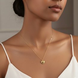 Gold heart-shaped pendant necklace on a delicate chain.