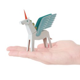 A whimsical white and blue pegacorn (a mythical creature that is a combination of a pegasus and a unicorn) postcard. The pegacorn has colorful wings and a horn, and is perched on a hand.