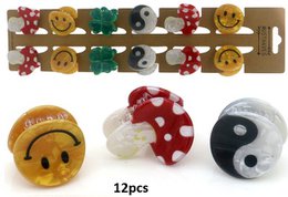 The image shows a set of 12 hair clips in various shapes and colors, including round, heart-shaped, and yin-yang designs. The clips appear to be made of plastic or resin and feature decorative elements like polka dots, flowers, and other patterns. This product would be suitable for use in hair styling and accessorizing.