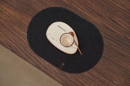 Oval-shaped black felt placemat with a simple, minimalist design.
