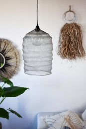 Silver wire mesh lampshade with a cylindrical shape and textured surface.
