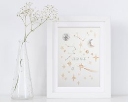 Watercolor wall print featuring a starry night sky design with crescent moon and scattered stars in shades of white, gold, and gray. Suitable for home decor or nursery.