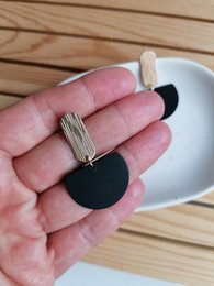 Statement earrings with a gold-black color scheme and a half-circle shape.
