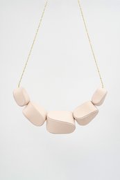 Geometric pendant necklace with irregular shaped beads in dusty blue, red wine, dusty green, light pink, dusty lilac, black, and spring green.