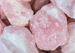 A greeting card featuring a rose quartz gemstone. The card is made of a soft pink material with natural variations in color and texture, creating a unique and natural look.