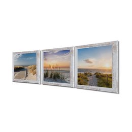 Framed mural depicting a scenic beach landscape with sand dunes, grassy vegetation, and a sunset over the ocean. The image showcases the natural beauty of a coastal setting.