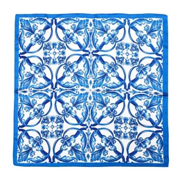 Blue and white geometric floral pattern silk scarf with symmetrical ornamental design.