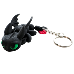 Black flexible dragon keychain with green eyes, red wings, metal ring attachment