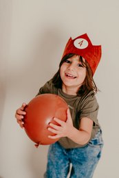 A red felt crown with a white number 1 in the center, designed for children's birthday celebrations.