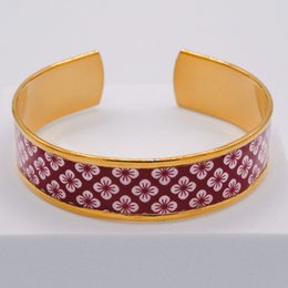 Elegant gold-tone bangle bracelet with intricate Japanese-inspired floral pattern in shades of purple.