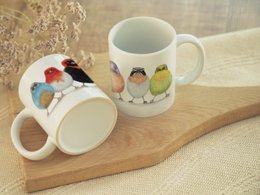 Ceramic mug featuring colorful African bird designs, suitable for use as a funny animal-themed coffee or tea cup.