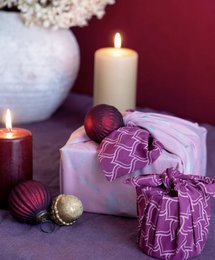 Burgundy and blush furoshiki wrapping paper with silver whale patterns. Includes various furoshiki wrapping techniques and accessories like candles and ornaments.