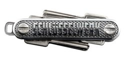 A sleek and compact key organizer made of durable metal with a textured surface and a keyring attachment.