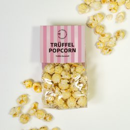 Delicious truffled popcorn in a striped bag. Fluffy, golden popcorn kernels with a savory truffle flavor.