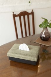 Handwoven tissue box holder, rectangular shape, natural beige linen material with black trim, functional home decor.