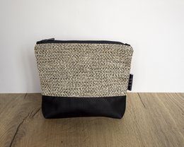 A black and beige toiletry bag with a textured pattern.
