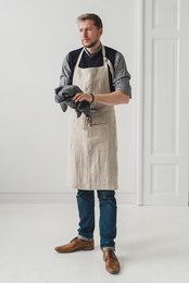  Unisex linen apron in various neutral colors including natural, white, gray, and black. Features a simple, minimalist design suitable for both men and women.