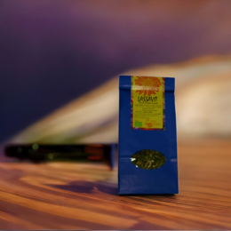 Organic herbal tea in a blue box with a yellow label, featuring a natural, earthy background with moss and foliage.