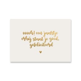 A gold foil-stamped birthday card with a heartfelt message in a cursive font. The card features a simple, elegant design with a warm, celebratory tone.