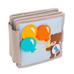  A quiet book with a bear character, colorful balloons, and an ice cream cone. The book appears to be made of felt or fabric materials and is designed for young children's play and learning.