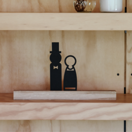 Decorative bride and groom figurines on wooden shelves
