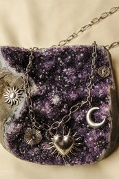  Amethyst crystal necklace with sun, moon, and star charms. Handmade jewelry with natural gemstone.