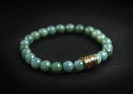 Elegant green beaded bracelet with gold-tone accent bead.