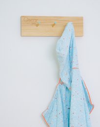 Wooden coat rack with blue patterned towel hanging on it. Wooden chair in the background.

The product is a COAT RACK LENNY, which is a kids room accessory. It is made of wood and has a simple, minimalist design. The image shows a blue patterned towel hanging on the coat rack, indicating that it can be used to hang various items such as towels, clothes, or accessories. The wooden chair in the background complements the overall style of the room decor.