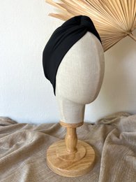 Dark gray headband made of soft, stretchy material. Simple, minimalist design suitable for everyday wear.