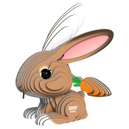 A 3D DIY craft kit in the shape of a rabbit, made of cardboard with a pink face, black eyes, and an orange carrot.
