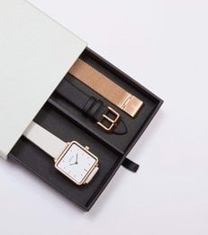 Rose gold and light grey watch set with leather strap and square face.