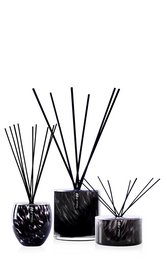 Elegant reed diffuser set with a dark glass container and black reed sticks, featuring a blend of truffle, ylang-ylang, and vetiver fragrances.
