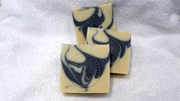 Handcrafted soap bars with a swirling black and white design, made with natural ingredients.