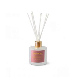 White cylindrical scented candle with gold lid, blue label, luxury home fragrance, aromatic decor.