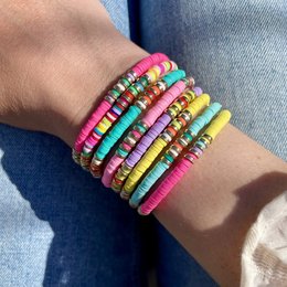  Colorful beaded bracelets in various vibrant shades including yellow, mint, pink, purple, turquoise, and neon pink. The bracelets feature a stacked, layered design with a mix of different bead shapes and textures.