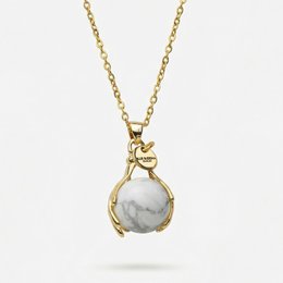  Necklace with a howlite stone pendant in a gold-tone setting, on a delicate gold-tone chain. The howlite stone is known for its calming properties.