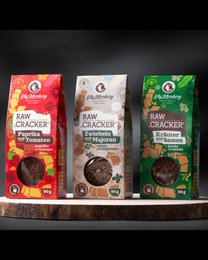 Raw flax seed crackers in a box of 3, made from natural ingredients. Contains flax seeds, sunflower seeds, and tomato. Suitable for snacking.