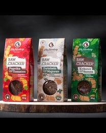 Raw flax seed crackers in a box of 3, made from natural ingredients. Contains flax seeds, sunflower seeds, and tomato. Suitable for snacking.