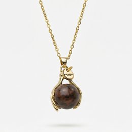 A gold necklace with a mahogany obsidian pendant in a round shape. The pendant is suspended from a delicate gold chain.