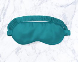 Teal silk sleep mask with soft, comfortable design for restful sleep.
