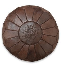 A round, brown leather pouf with a decorative star pattern in the center.