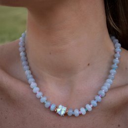 Blue gemstone beads necklace with bow detail, made of light blue gemstones and gold-tone accents.