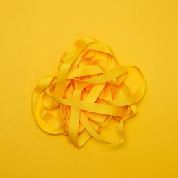 A bright yellow ribbon with the text "MY PRETTY CIRCUS" printed on a black label. The ribbon appears to be made of a soft, satin-like material and is coiled in a decorative manner.