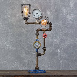 Vintage industrial-style table lamp with exposed pipes, gauges, and Edison bulbs. Rustic, steampunk-inspired design.